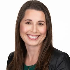 A woman with long brown hair is smiling for the camera.