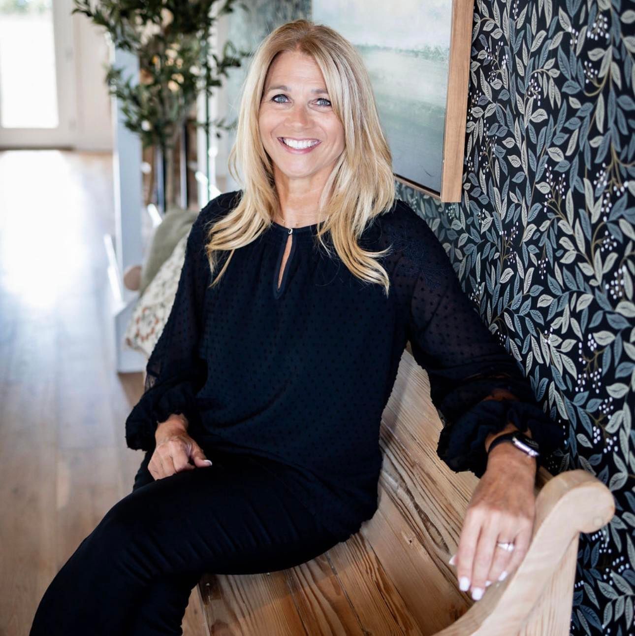 A woman in a black top is sitting on a bench