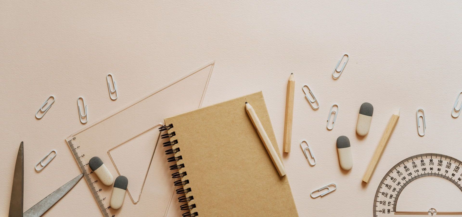 A brown notebook is surrounded by school supplies