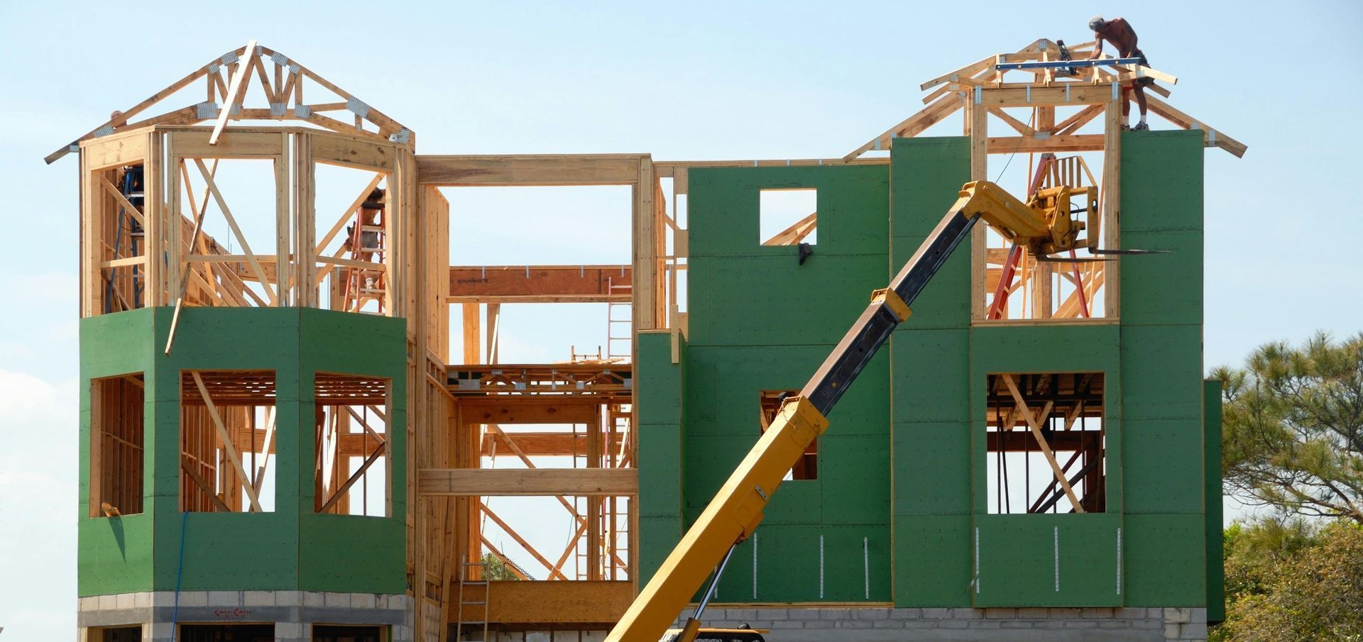 A large house is being built with a crane in front of it