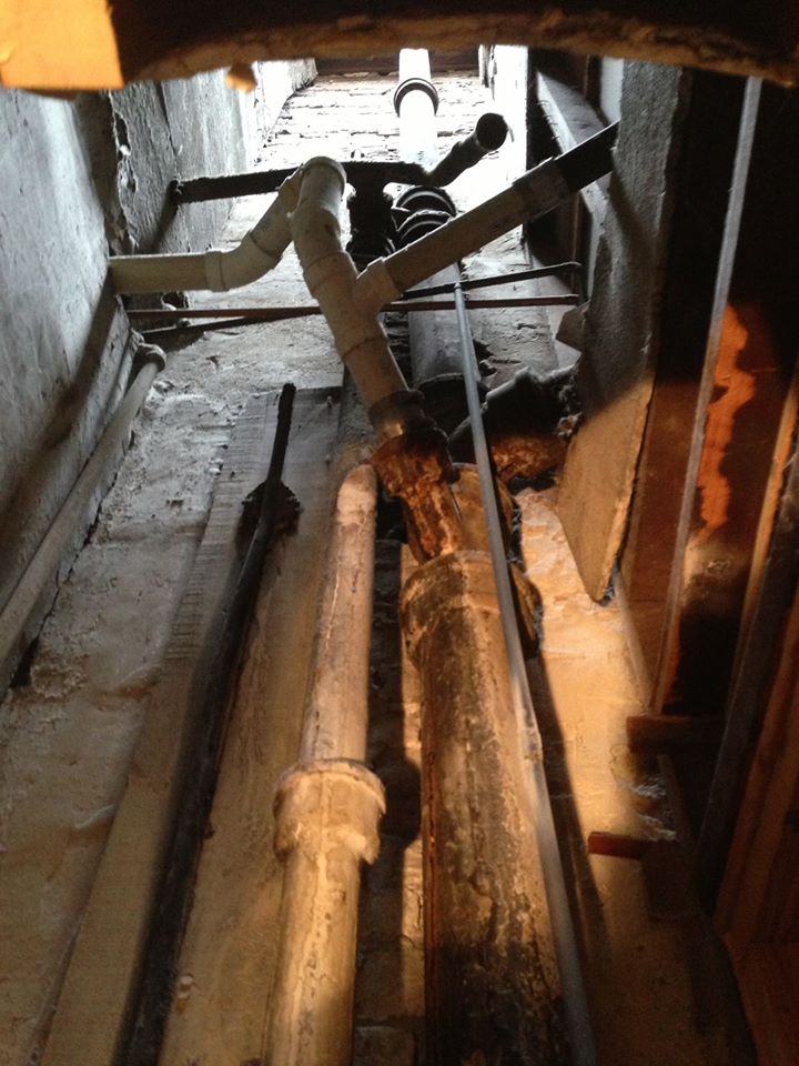 A bunch of pipes are laying on the floor in a dark room.