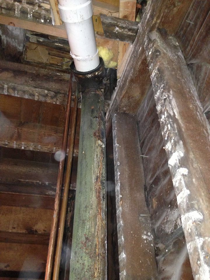 A pipe is hanging from the ceiling of a building.