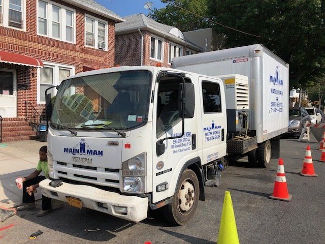 A white truck is parked in front of a brick building.