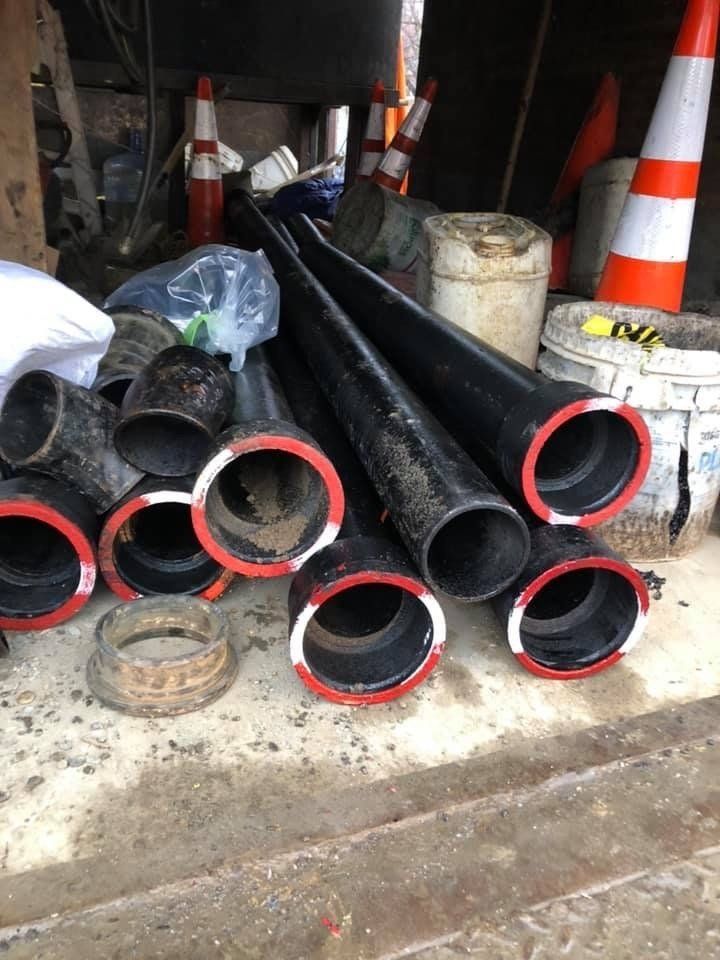 A bunch of pipes are stacked on top of each other on the ground