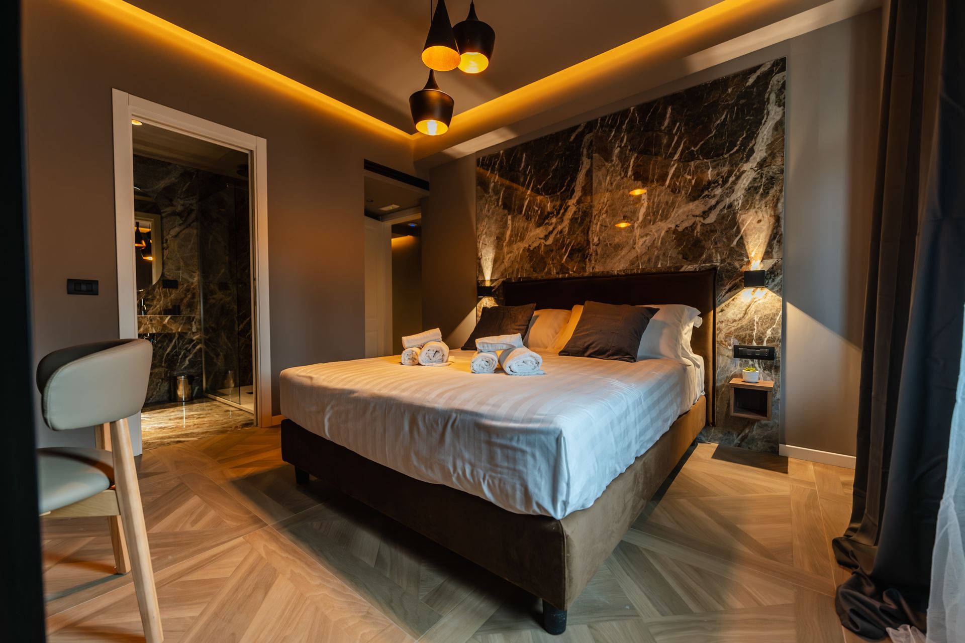 Soggiorno con divano componibile grigio, TV ed estintore vicino a una finestra.