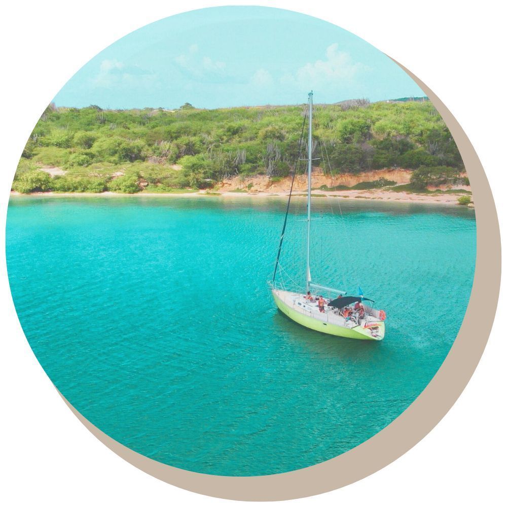 Couple on a sailboat toasting with champagne; blue sea and sky in background.
