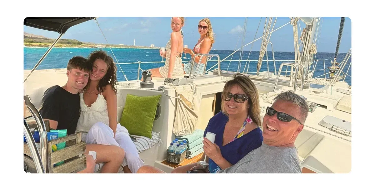Galaxie at sunset cruise on Caribbean Sea with happy family in shaded cockpit