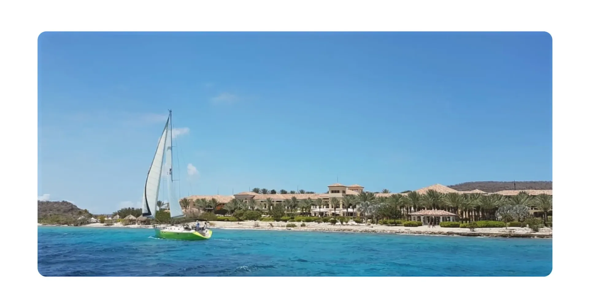 Green sailing yacht Galaxie sailing along Sandals Resort Curacao