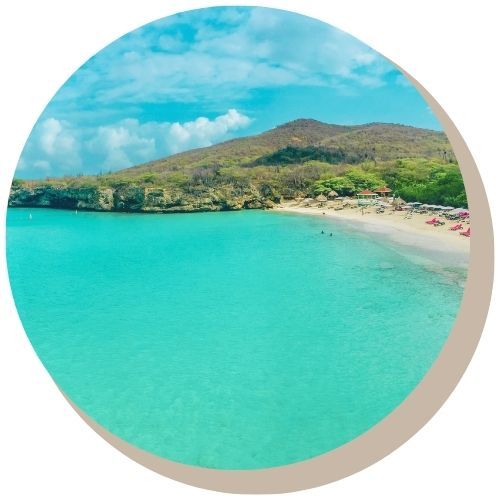 Wooden bridge with arched lights over water, colorful Curacao