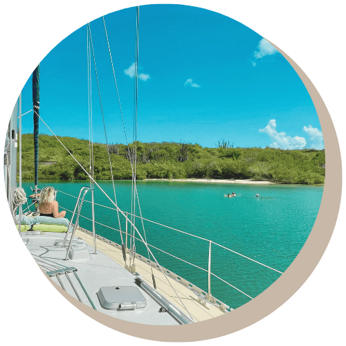 Mother and daughter and grand daughter in a turquoise bay, drinking beverages, one snorkeling.