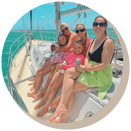 People on a sailboat Galaxie, enjoying the sun. Turquoise water, smiling faces, drinks in hand, sunny day.