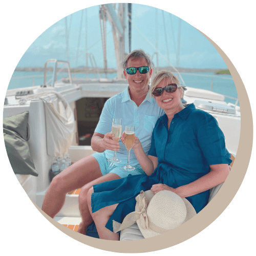 Couple toasting champagne on a private boat, sunny day, blue water.