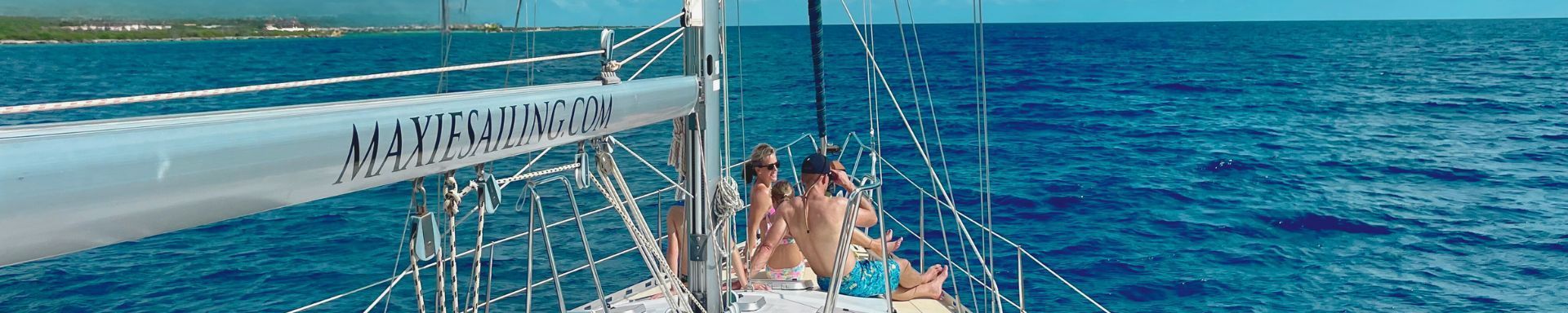 Cruise Travelers at the blue Caribbean sea on the front deck of sailing yacht Galaxie