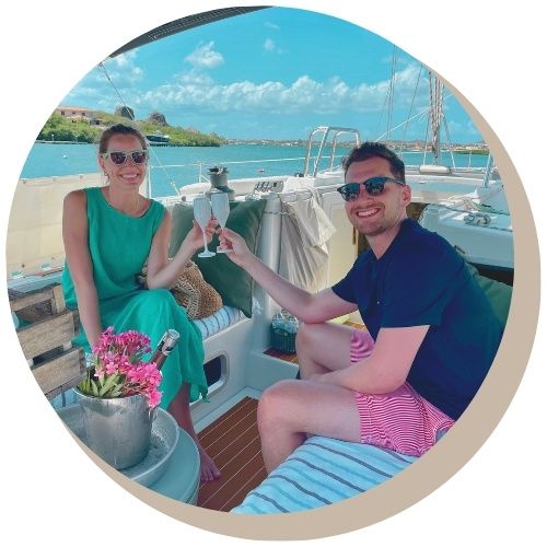 Romantic Couple toasting champagne on a sailboat Galaxie; water and blue sky in background.