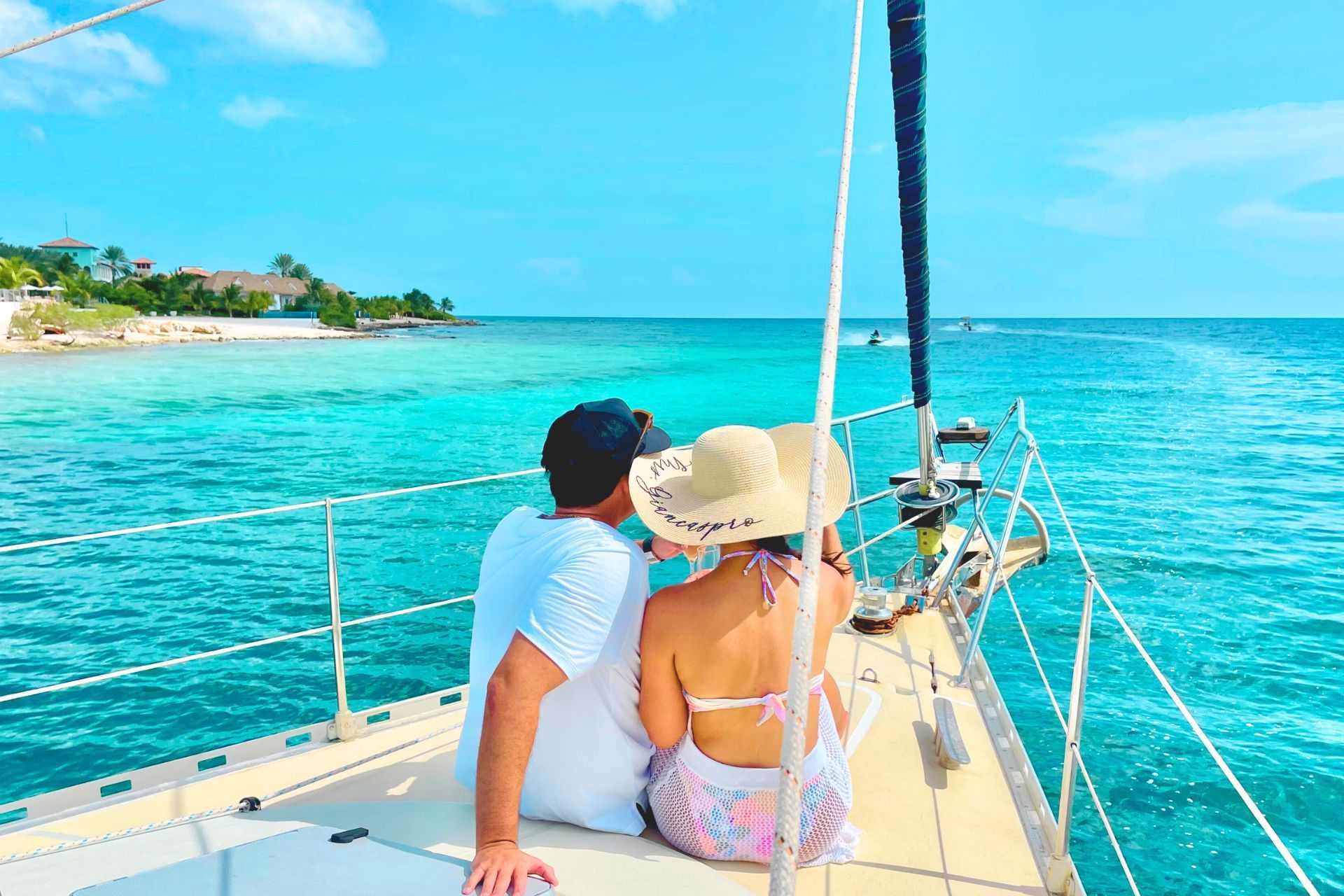 A man and a woman are sitting on the deck of a sailboat looking at the sea