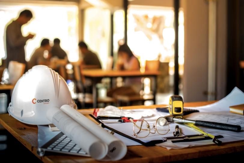 Drawings and Engineering Tools Placed on Top of a Wooden Table — Construction Services in Southport, QLD