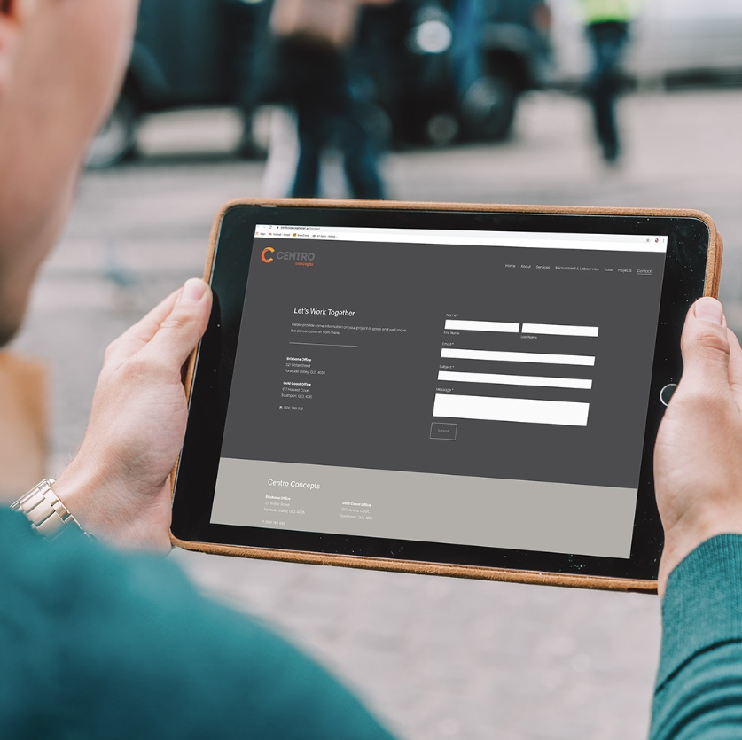 Man Holding an Ipad With Centro Concepts Website — Construction Services in Southport, QLD