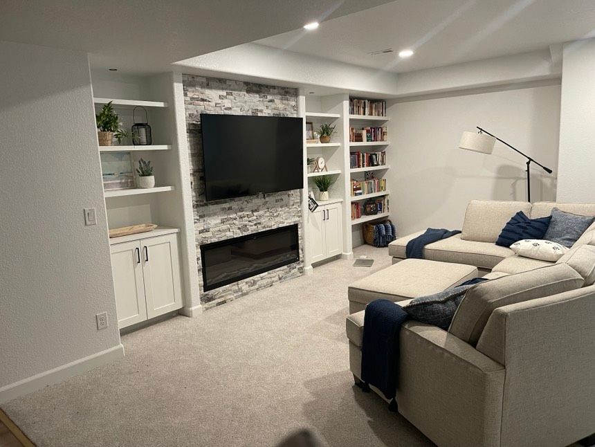 A living room with a couch , television and fireplace.