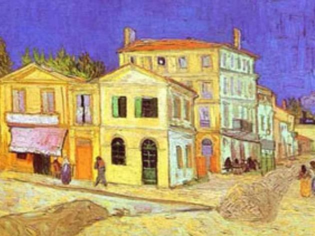 a painting of a row of yellow buildings with people walking in front of them .