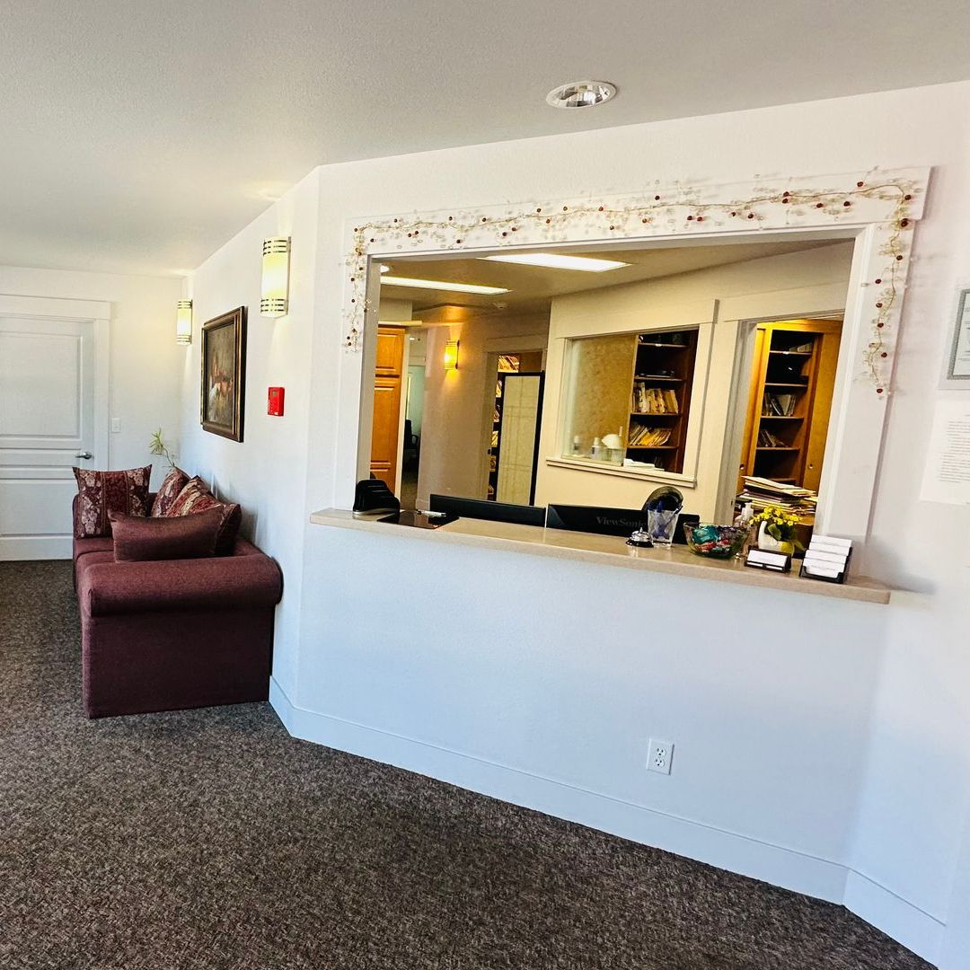 A living room with a couch and a mirror on the wall.