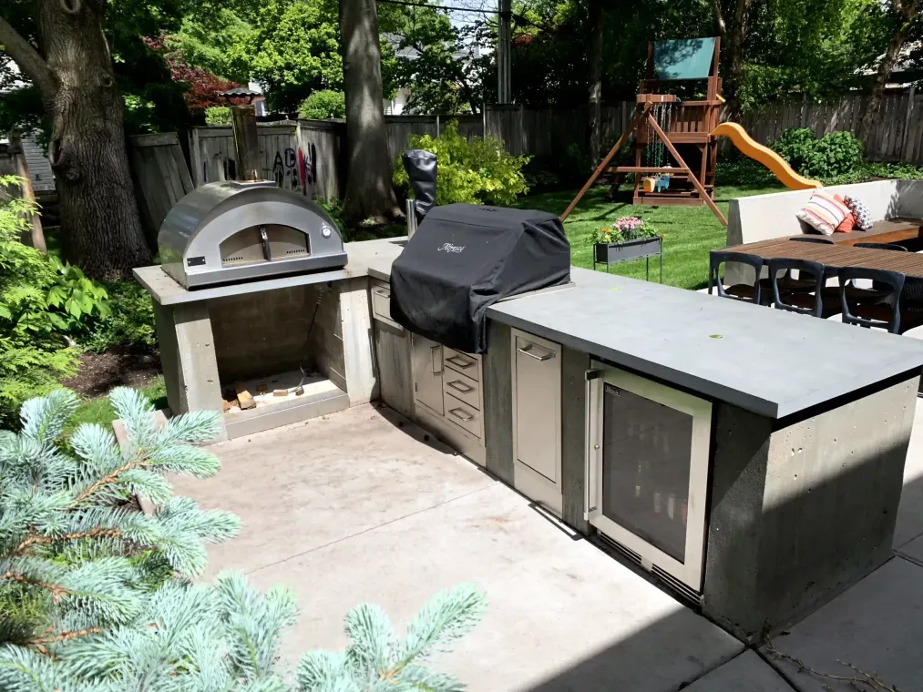 A backyard with a grill and a pizza oven