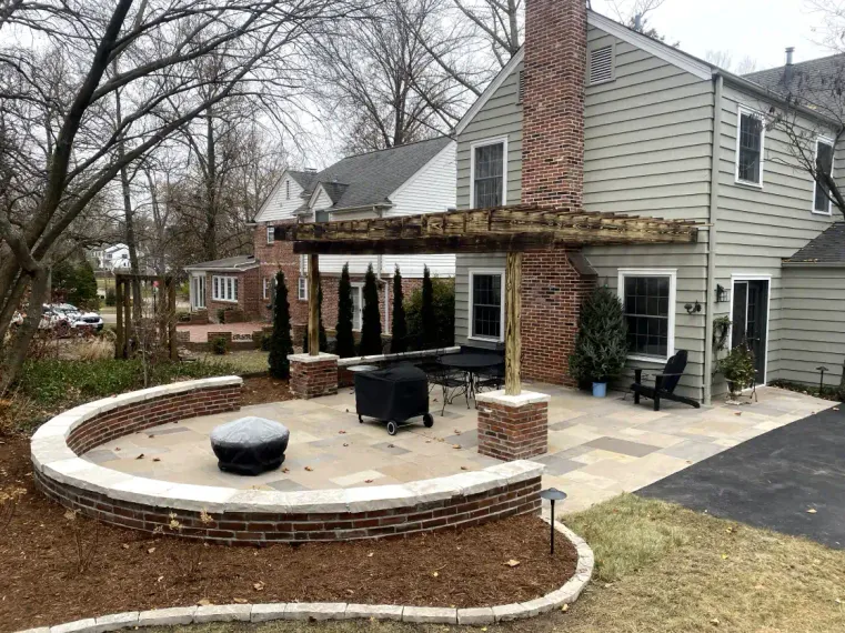 A house with a patio and a fire pit in front of it.