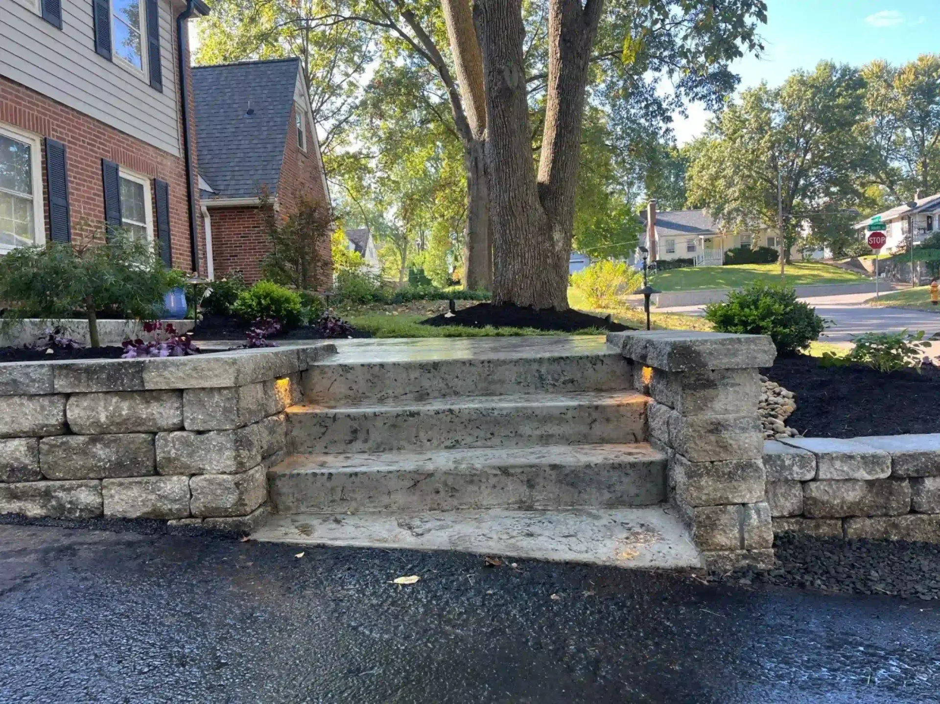 A stone wall with stairs leading up to a house.