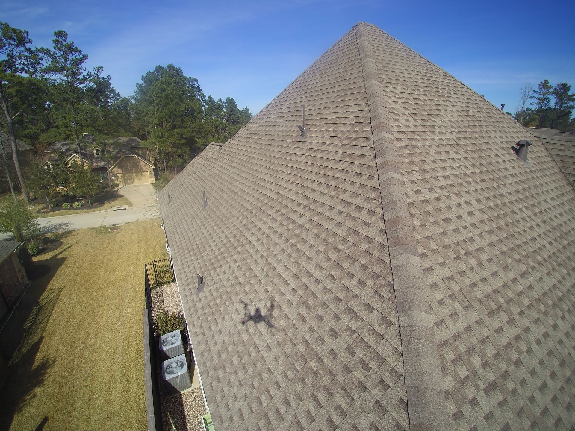 A man wearing a hard hat is working on a roof.