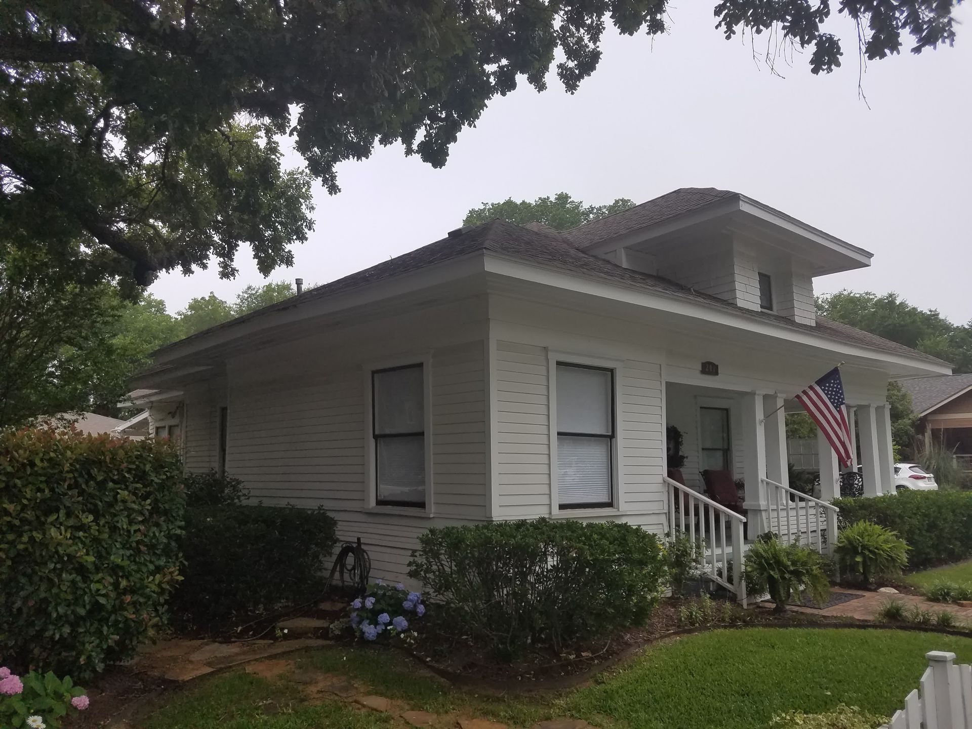 a man wearing a black and orange shirt is working on a house