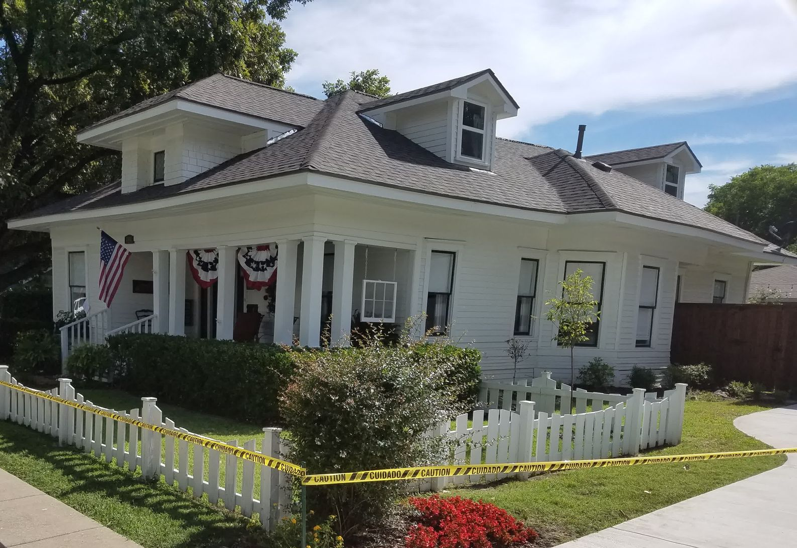 A man is standing on a ladder on the side of a house.