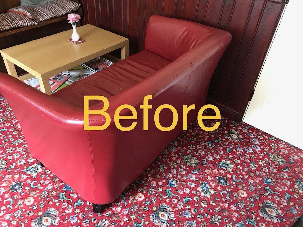 Red leather sofa in a pub with table and red carpet