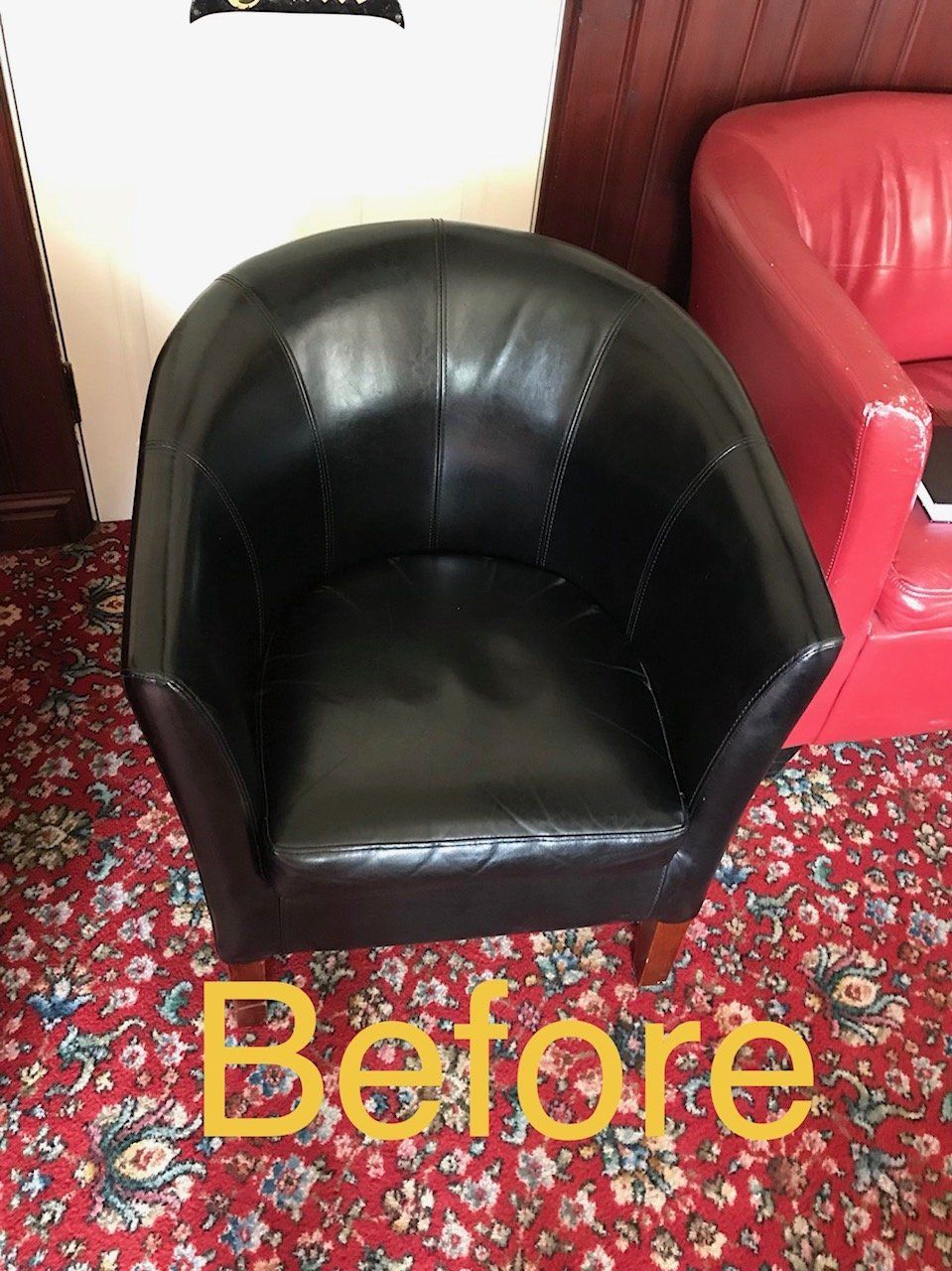 Round black leather chair on a red carpet in a pub