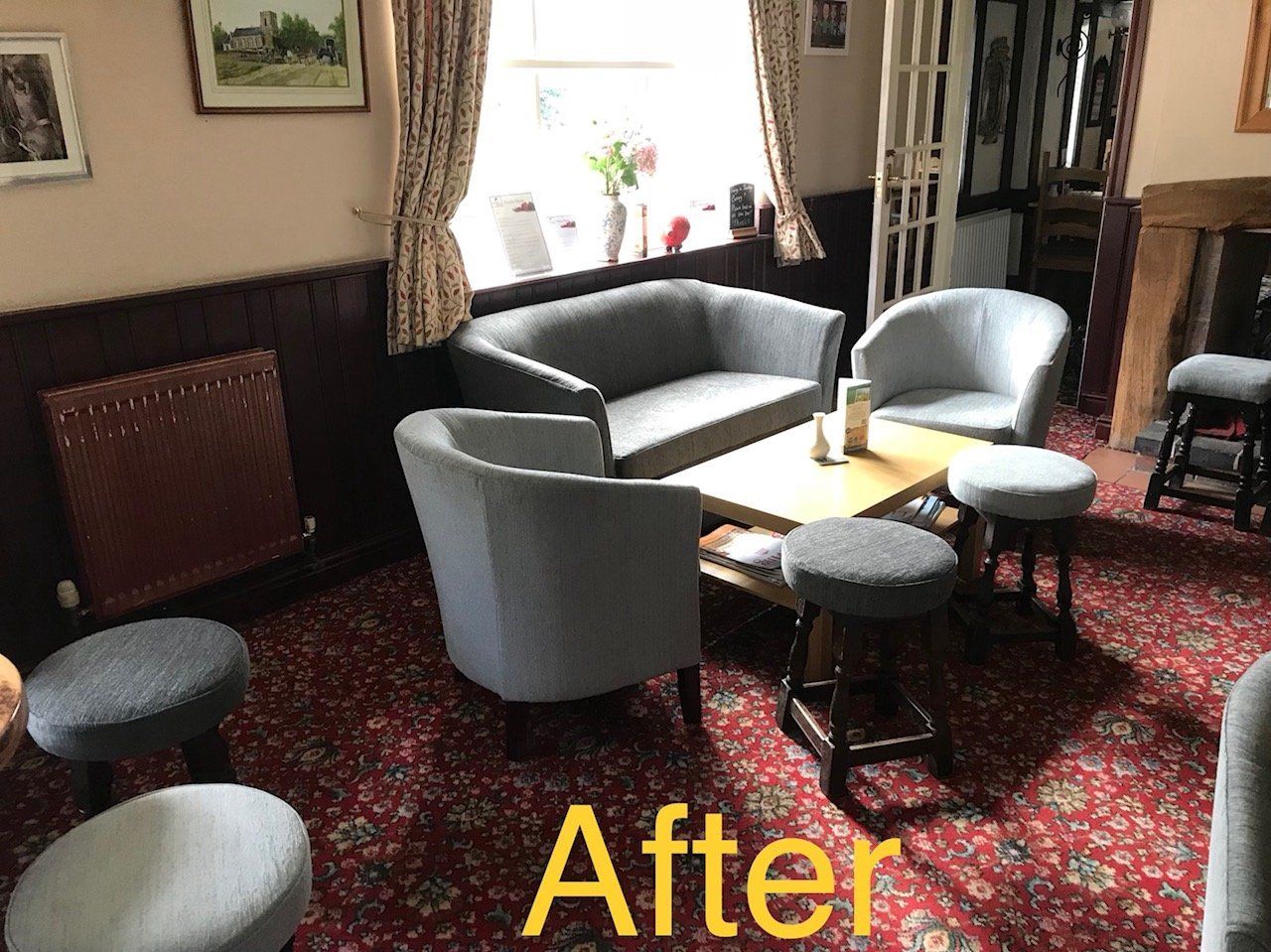 Seating and table in a bright pub with a red carpet
