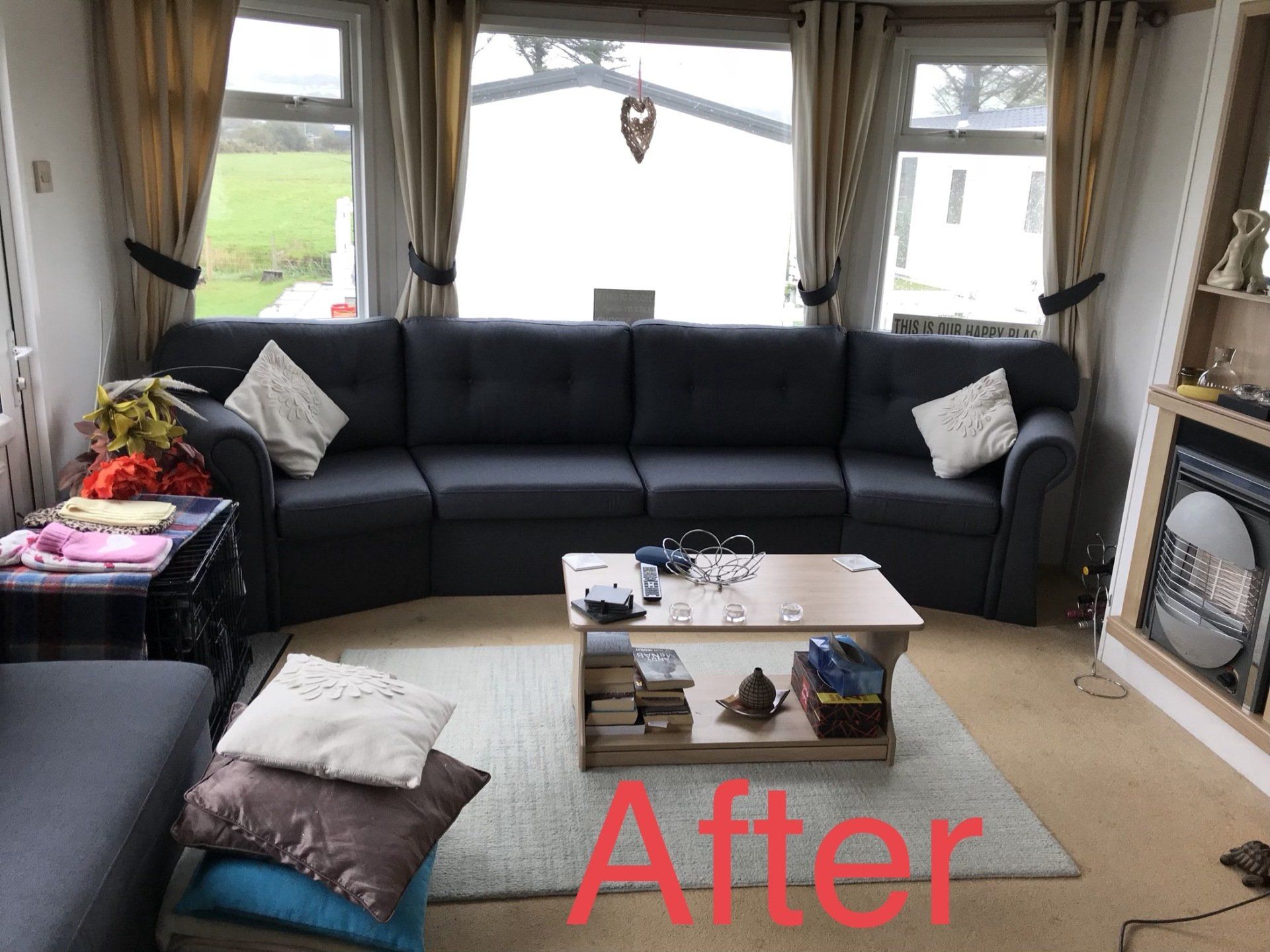 Black sofa in front of a large window with a coffee table