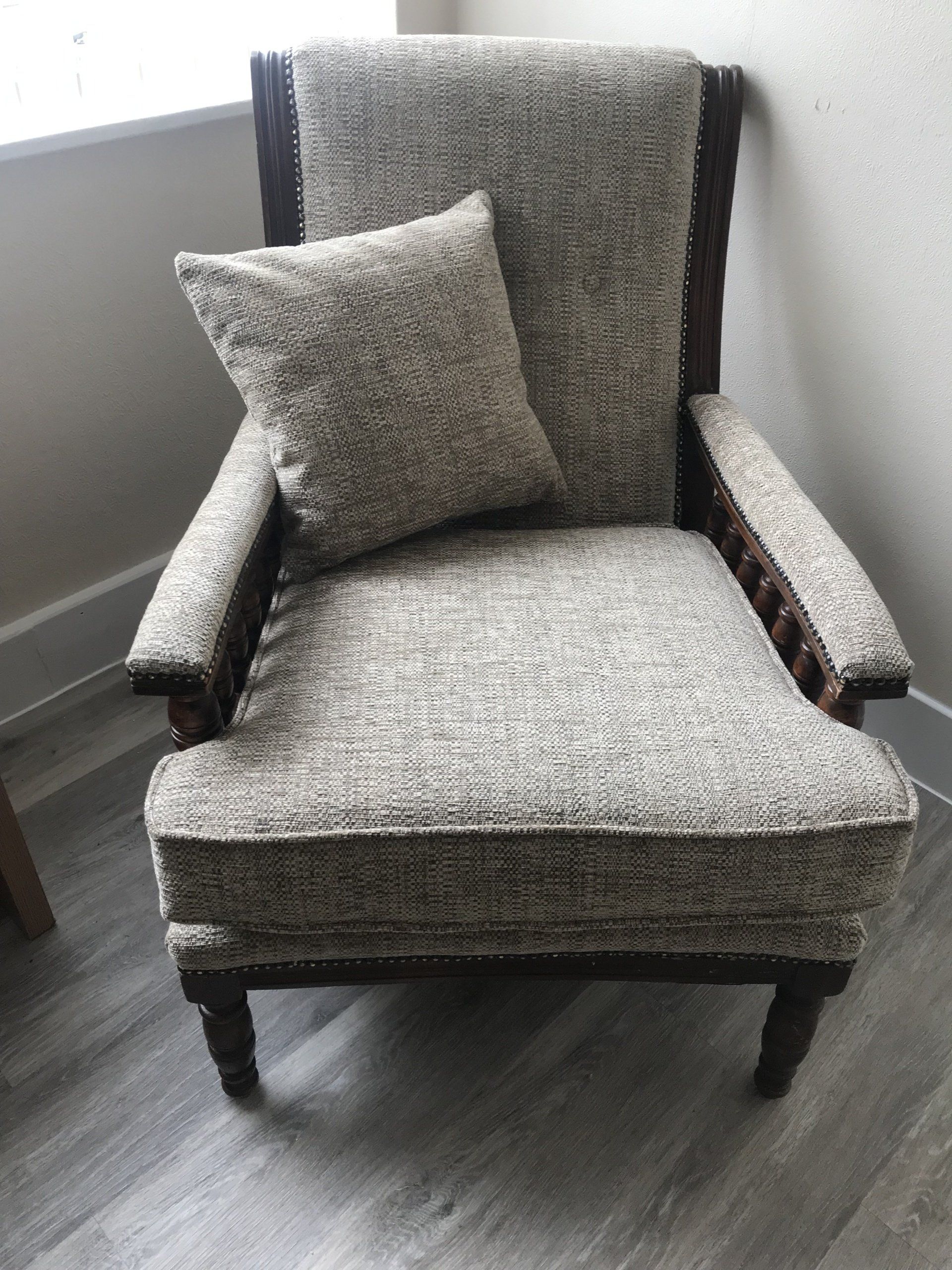 Grey armchair with wooden legs and a matching cushion