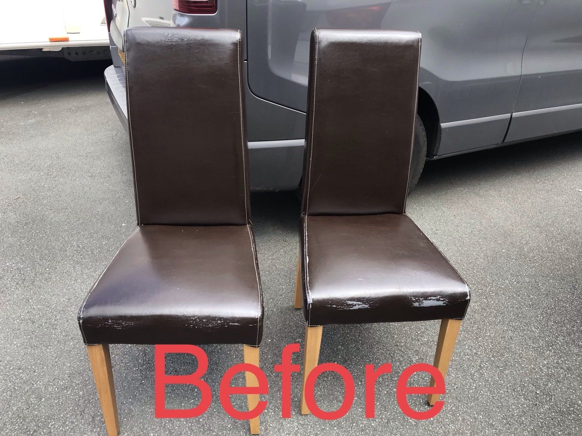 Two leather dining room chairs in front of a car