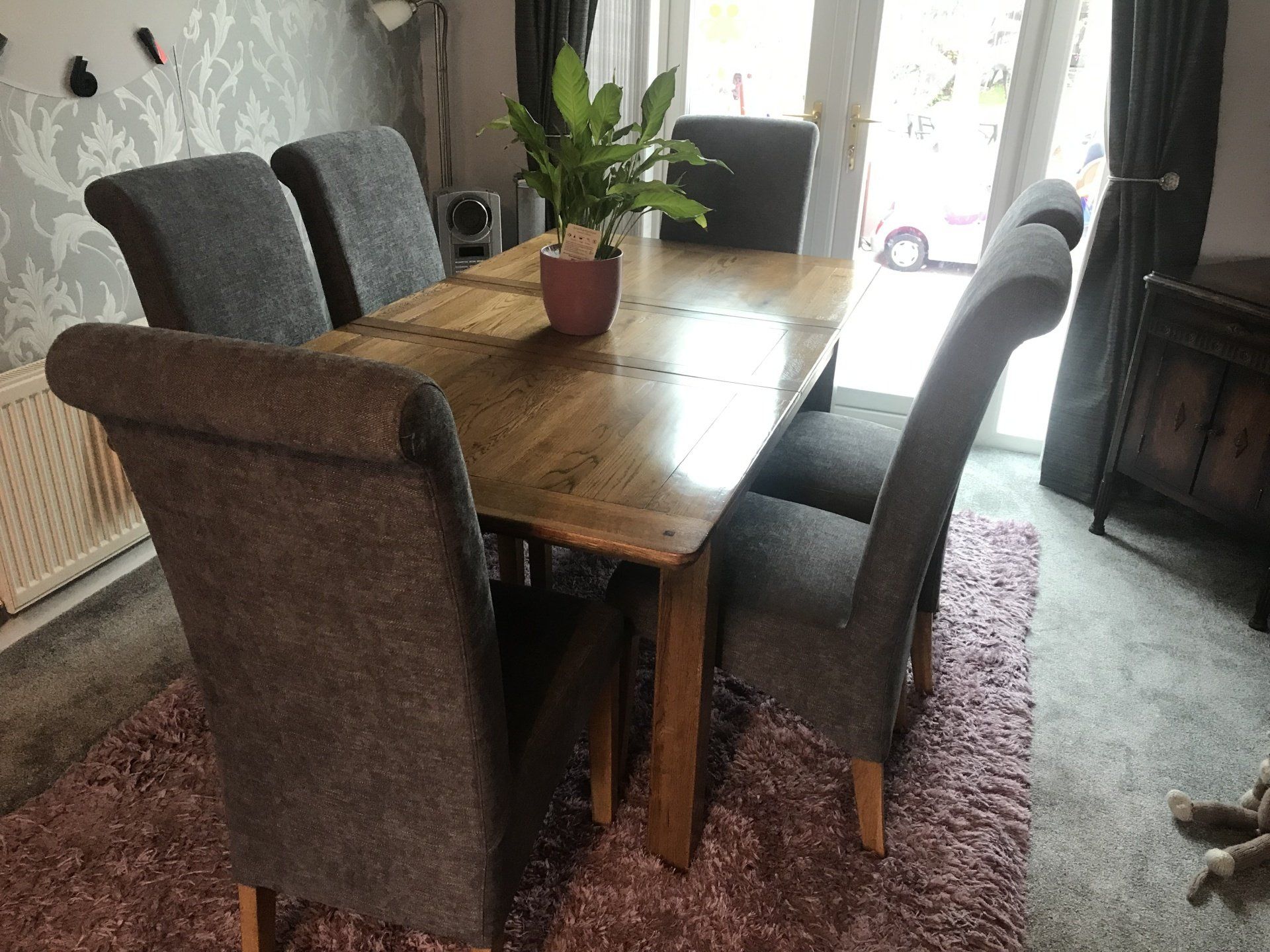 Rectangular dining table with a plant on it and chairs around it