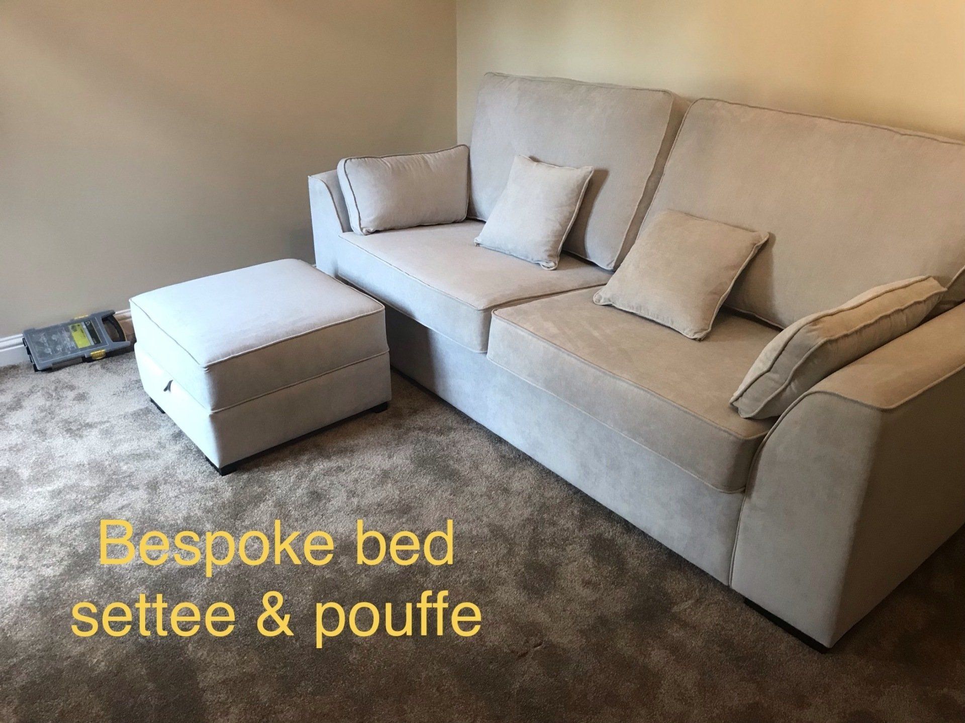 A footstool next to a sofa with matching upholstery