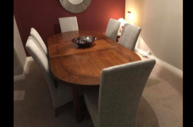 Round dining tables with chairs in front of a red wall