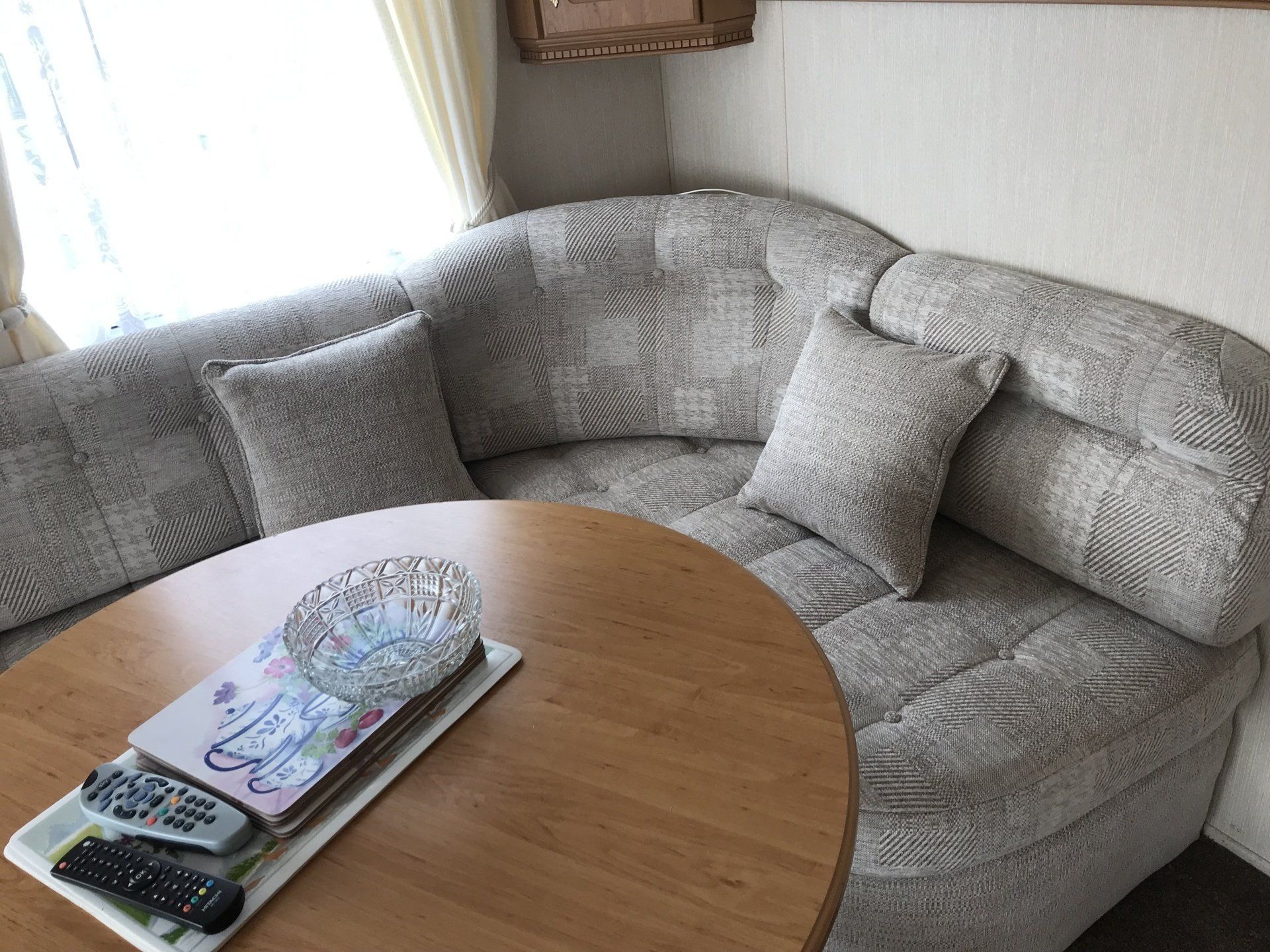 Close up of a corner set with cushions and a round wooden table