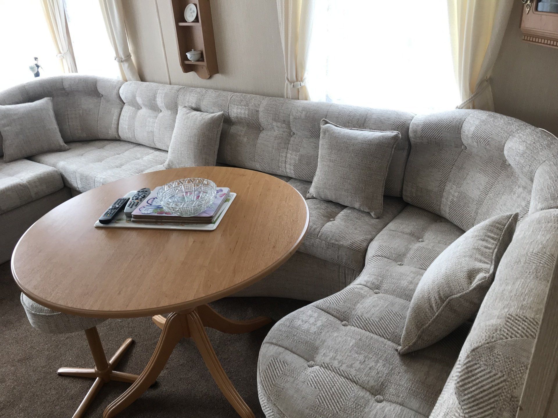 Curved corner set with cushions and a round wooden table