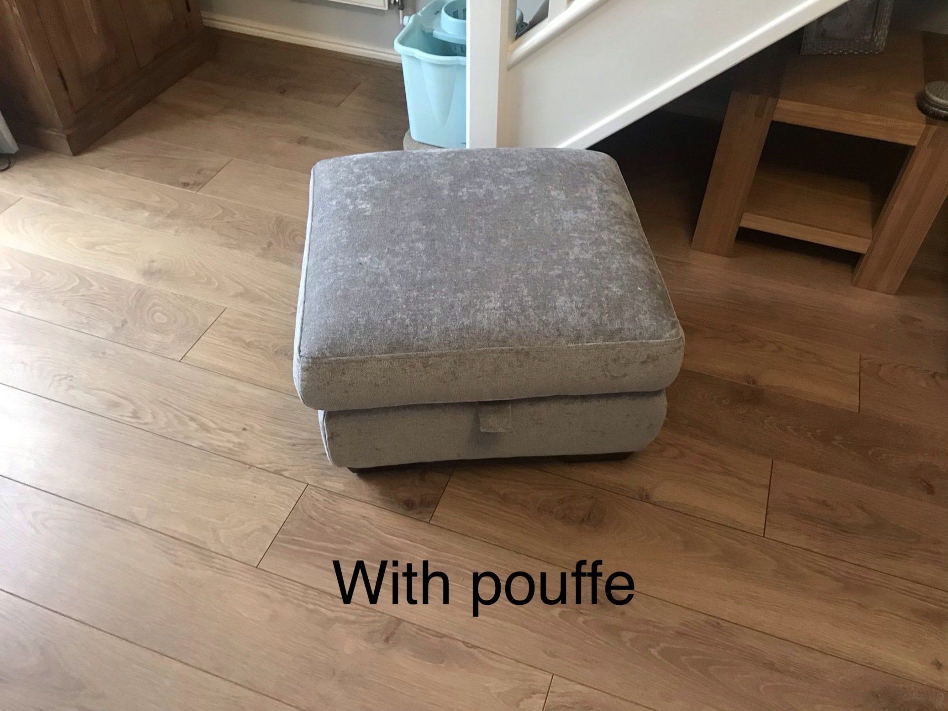 Grey pouffe on a brown wooden floor