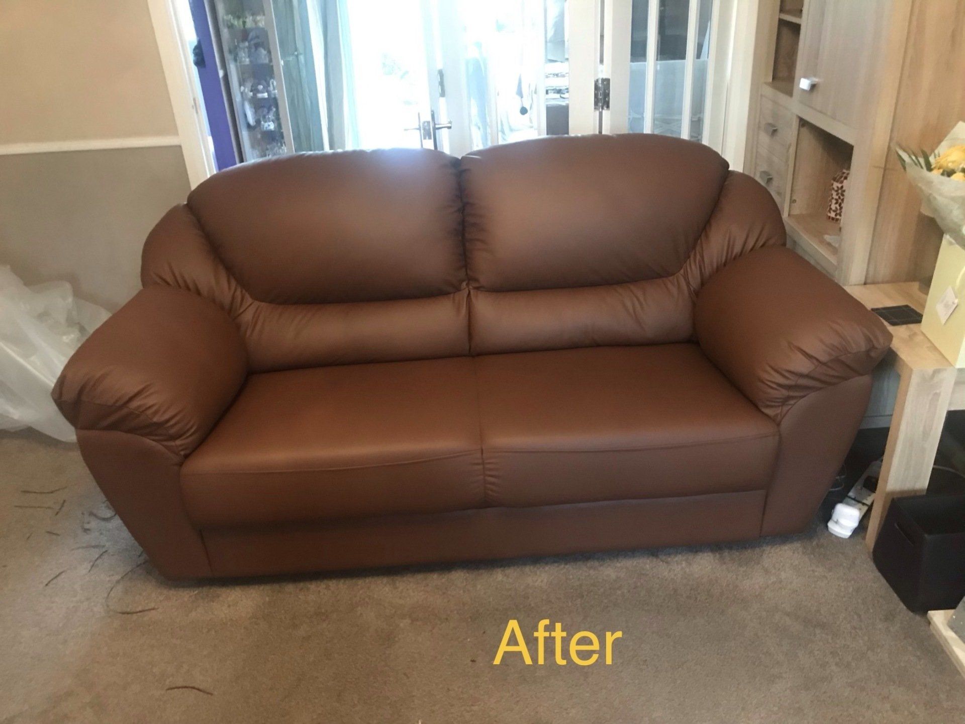 Straight on view of a small brown leather sofa