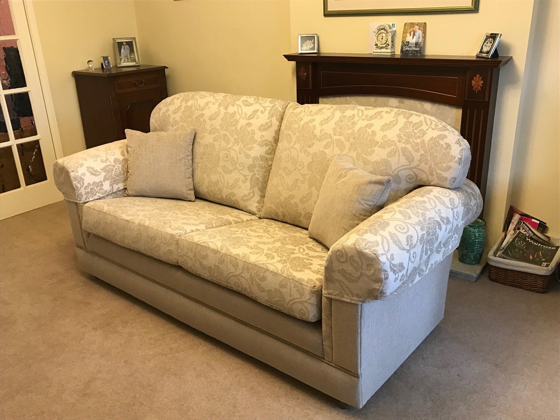Sofa with light grey patterned upholstery and cushions