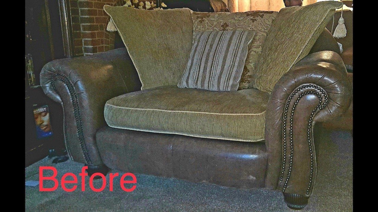 An old fashioned looking green and brown chair with a cushion on it
