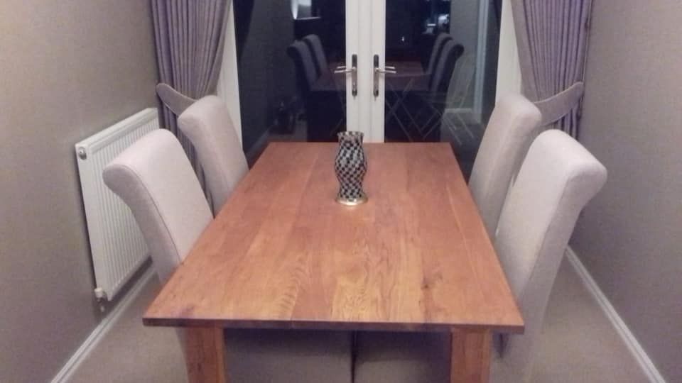 Wooden dining table with grey chairs around it
