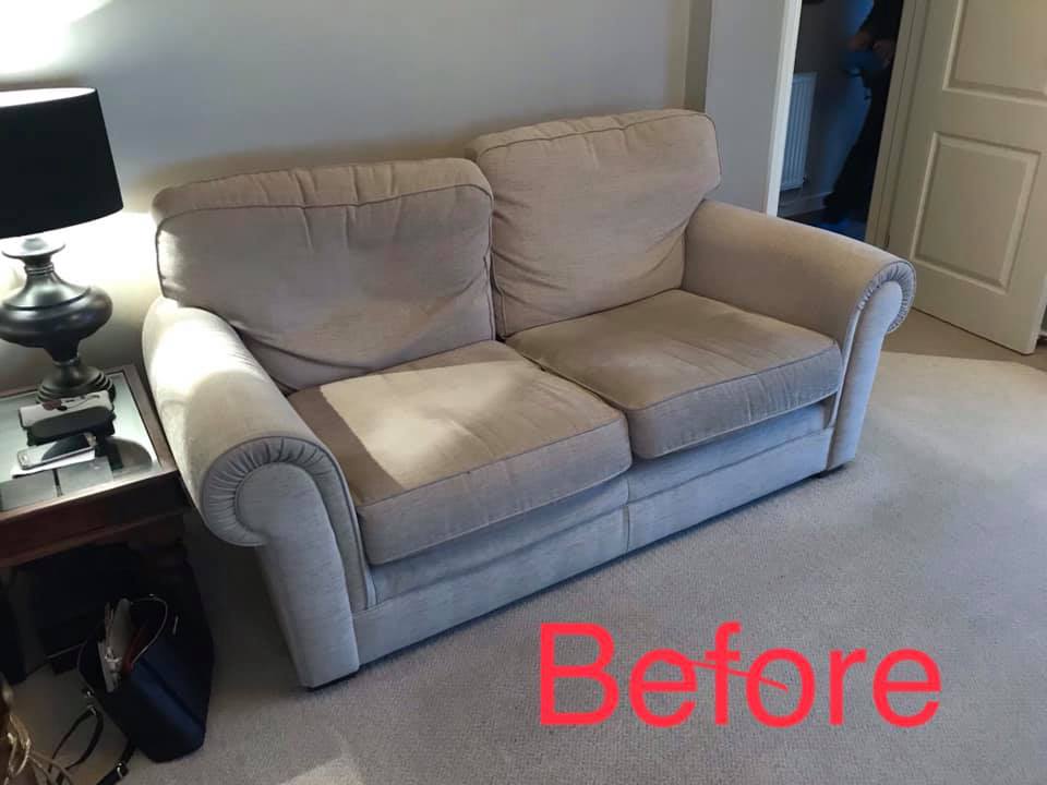 Side view of a tired and misshapen grey sofa