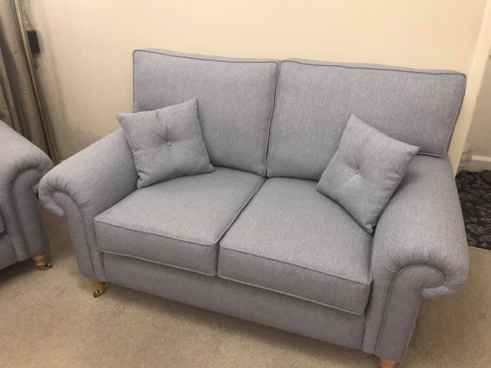A grey sofa with matching cushions