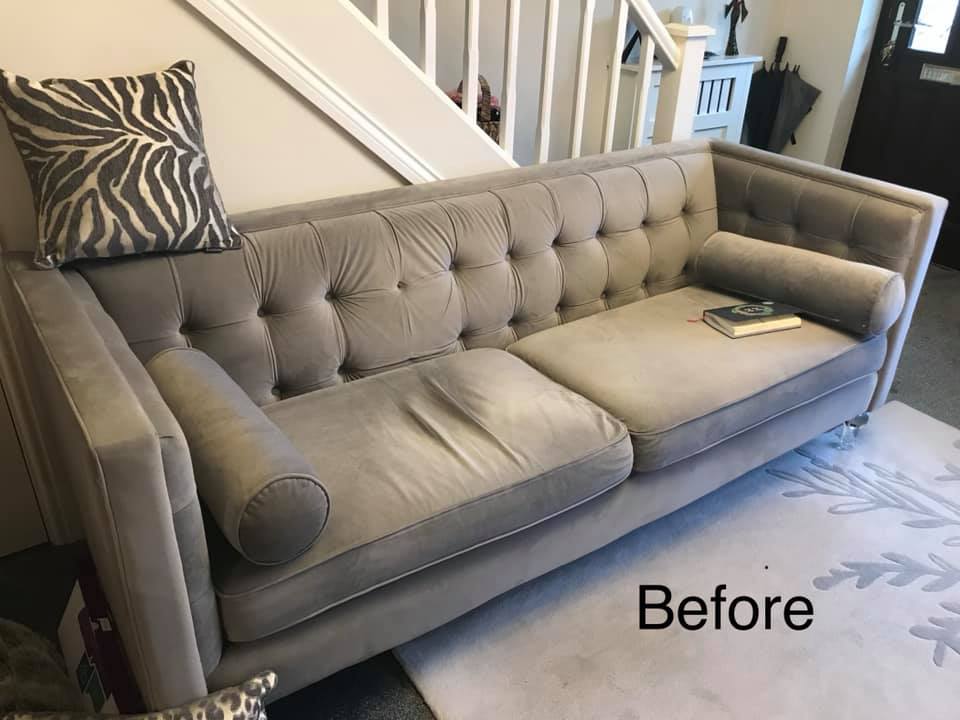 Large grey sofa in front of a white staircase