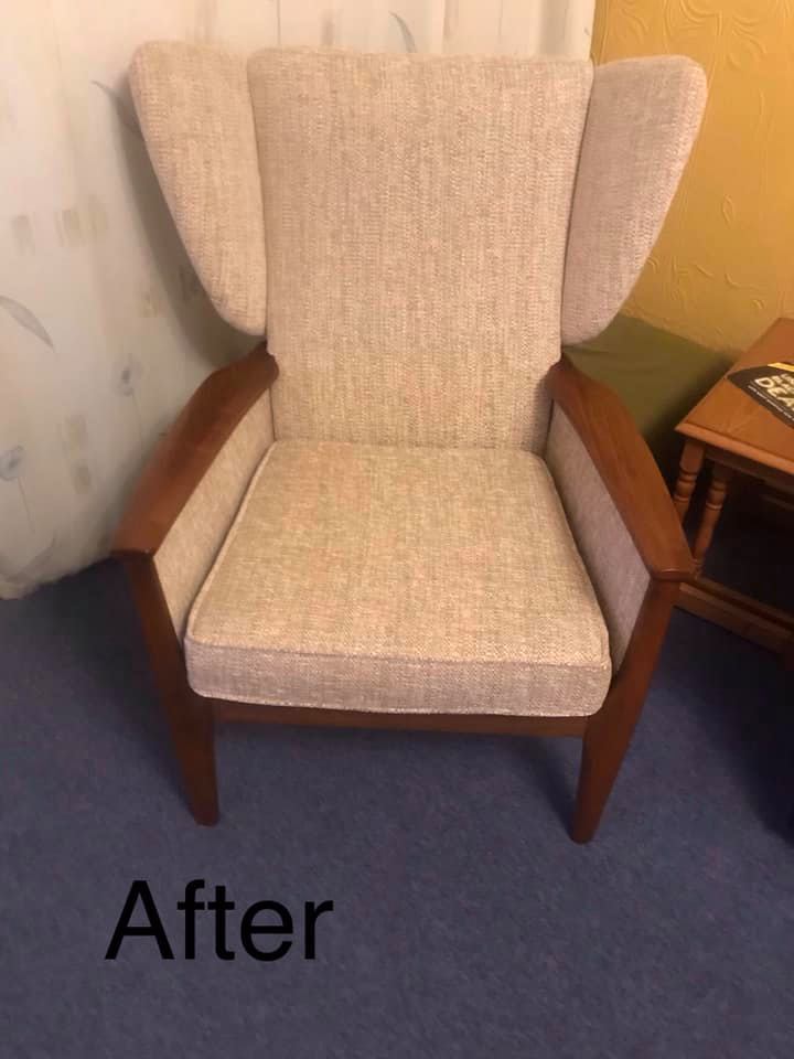 A wooden chair with beige upholstery in a yellow room